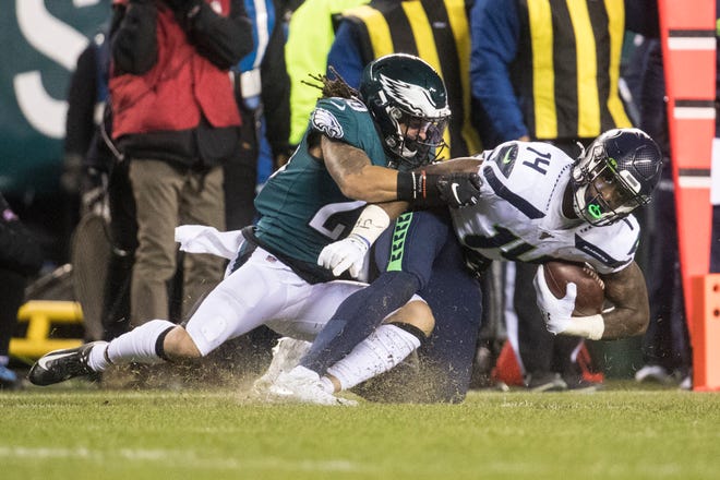 Seattle's DK Metcalf (14) is brought down by the Eagles' Avonte Maddox (29) Sunday night at Lincoln Financial Field. The Seahawks defeated the Eagles ending their season 17-9.