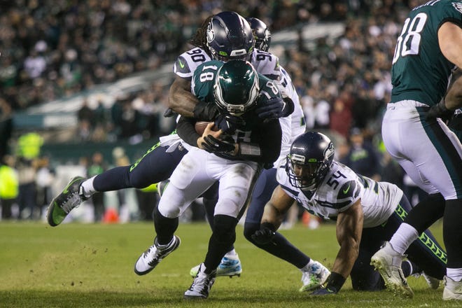 Eagles' Josh McCown (18) is brought down in the red zone Sunday night against Seattle. The Seahawks defeated the Eagles ending their season 17-9.