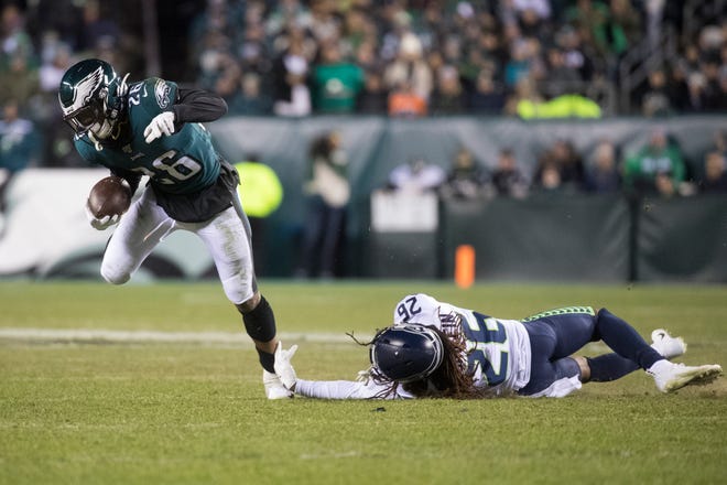 Eagles' Miles Sanders (26) gets away from the grasp of Seattle's Shaquill Griffin (26) Sunday night at Lincoln Financial Field. The Seahawks defeated the Eagles ending their season 17-9.