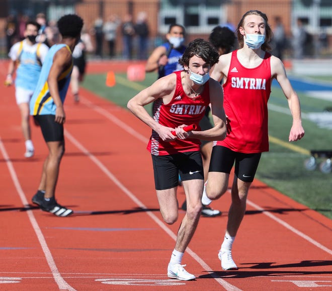 Smyrna's Brett Mathis (center) takes the baton from Liam Meginniss as they help their team to a win in the 4x400 relay during the DIAA state indoor track and field championships at Dover High School Wednesday, March 3, 2021.